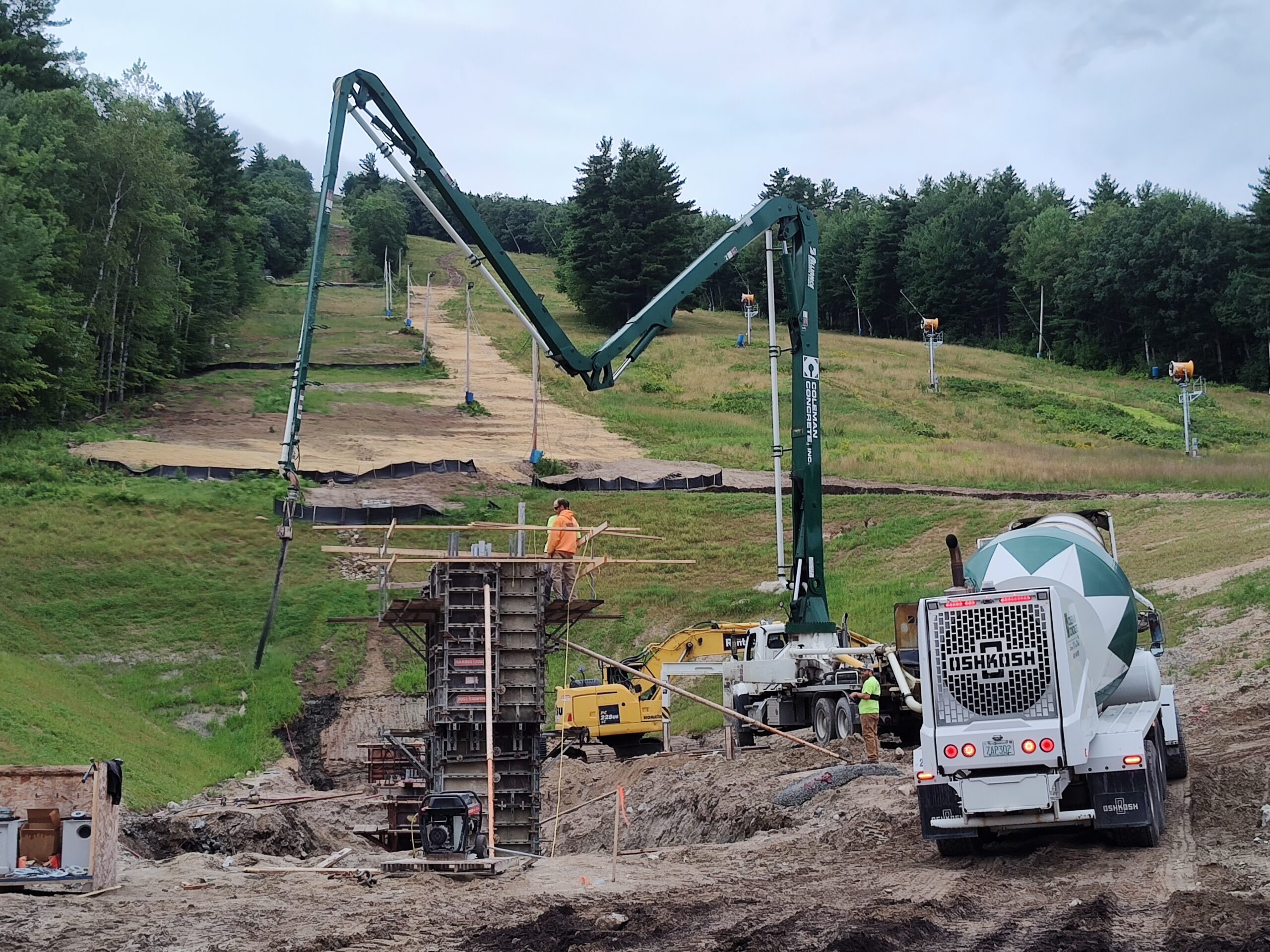 John Deere 210G Excavator performing finish grading, prepping slopes for erosion control at Pleasant Mountain Ski Area, Fall Line Construction.